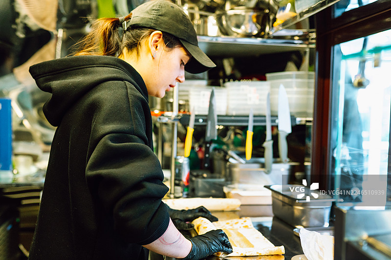 女厨师在商业厨房准备制作卷饼图片素材