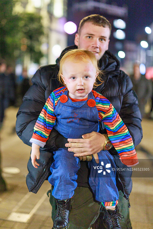 万圣夜，成人抱着身穿戏服的孩子图片素材