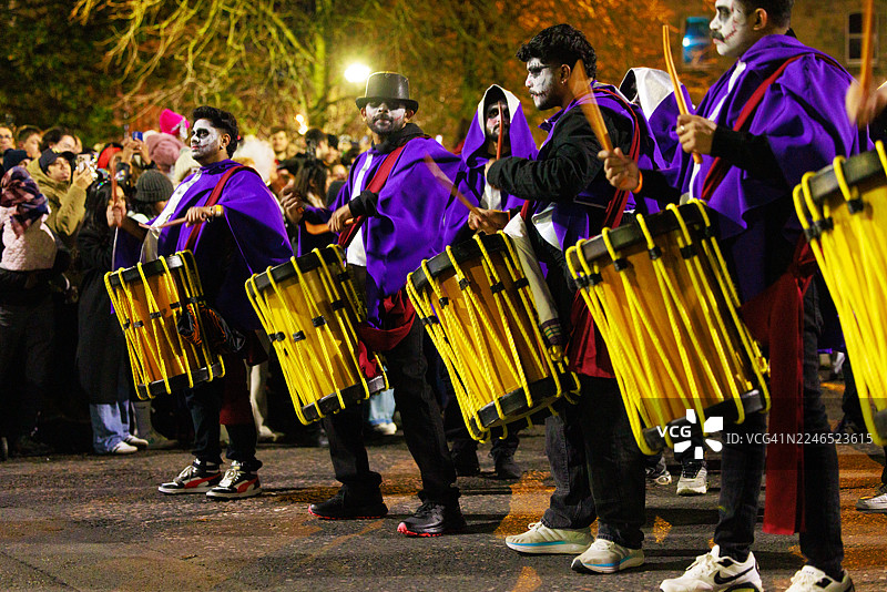 万圣节活动中戴着骷髅面具行进的音乐家图片素材
