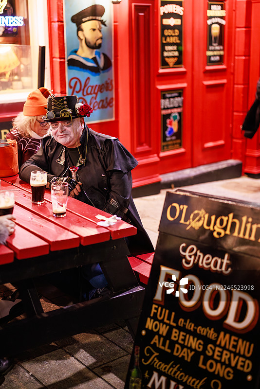 蒸汽朋克风格的帽子和妆容在户外酒吧桌旁图片素材