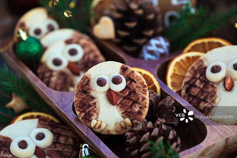 圣诞节的可爱猫头鹰形状黄油饼干，放在乡村木质背景上图片素材