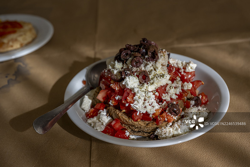 达科斯沙拉，一种典型的克里特岛菜肴，由大麦饼干、西红柿、碎菲达奶酪和橄榄组成，在希腊莱斯博斯岛的一家希腊酒馆供应。图片素材
