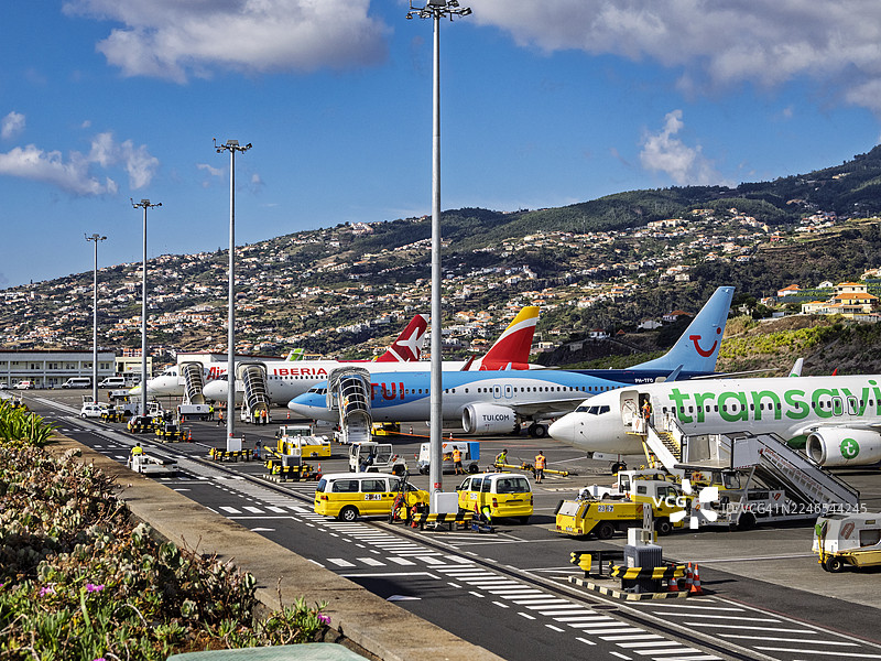 飞机停在马德拉丰沙尔的克里斯蒂亚诺·罗纳尔多国际机场航站楼前的跑道上。图片素材