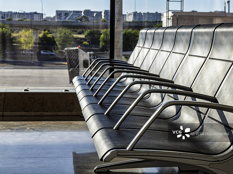 阳光照射下的机场候机室，一排座位上的长椅。图片素材