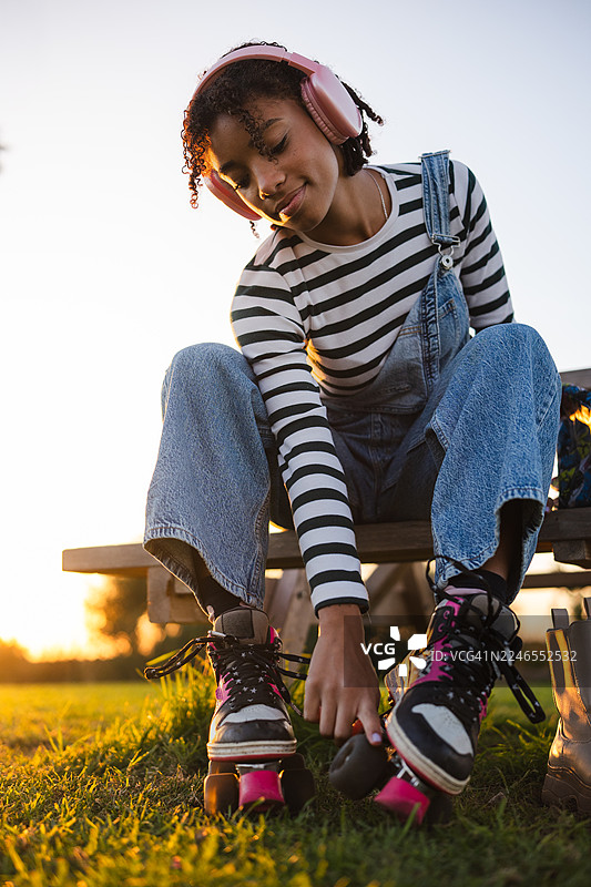 年轻女子坐在公园里穿轮滑鞋图片素材