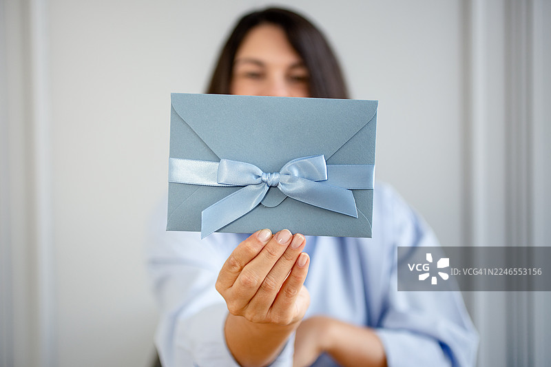 女子手中拿着证书和礼物。图片素材