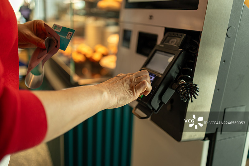 女性使用自助收银机结账图片素材