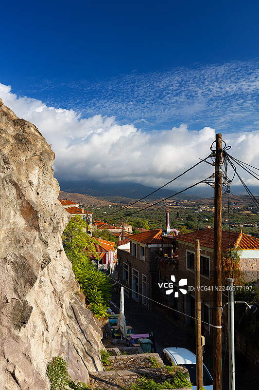 蓝天白云下，坐落在山坡上的传统村庄，远眺米蒂利尼的莫利沃斯城堡图片素材