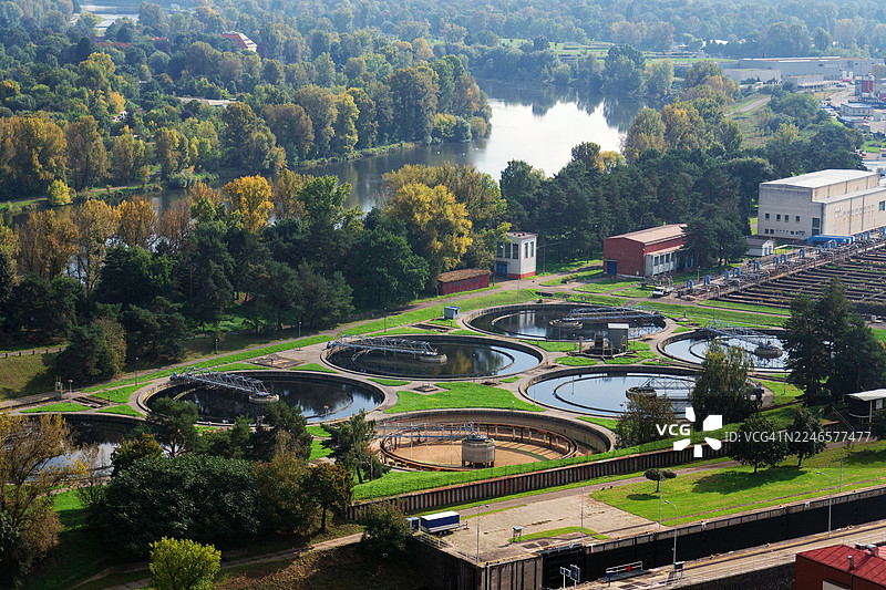 高视角俯瞰水处理厂，包含沉淀池和曝气池，周围环绕着绿植和河流，位于捷克共和国布拉格图片素材