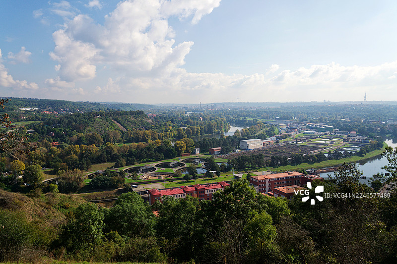 高角度全景视图，描绘了城镇风光，包括河流、山丘和工业设施，天空湛蓝，地点为捷克共和国布拉格。图片素材