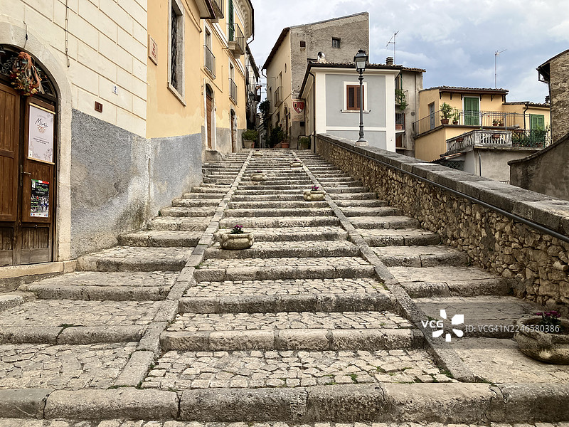 古老的鹅卵石台阶蜿蜒穿过迷人的欧洲村庄，周围是传统建筑图片素材