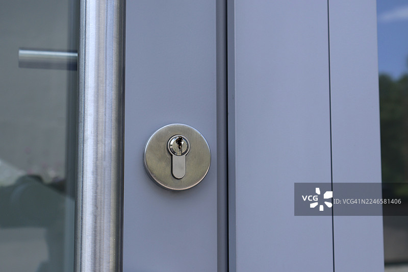 特写现代门，配有拉丝金属门把手和钥匙孔，强调安全与出入图片素材
