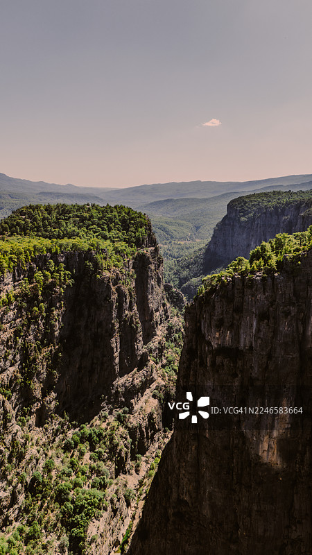 土耳其加济莱尔，晴空下的葱郁植被与壮丽峡谷风光图片素材