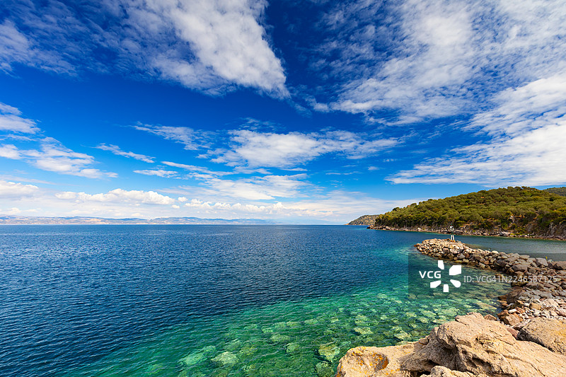 夏日晴空下，爱琴海的蓝天碧海，伴随着岩石海岸和葱郁的山丘，地点：希腊莱斯沃斯岛，斯卡拉西卡米尼亚图片素材