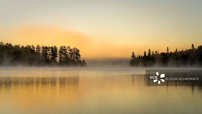日落时分，薄雾笼罩的湖泊与森林景观，加拿大蒂米斯卡明图片素材