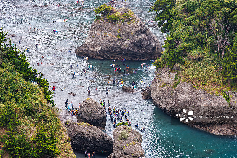 从海角天文台俯瞰的日里佐海滩美丽的蔚蓝大海。可以看到无人岛(如Ohnejima)、小岛和当地的岩石海岸。潜水者和浮潜者乘坐渔船在海上嬉戏。图片素材