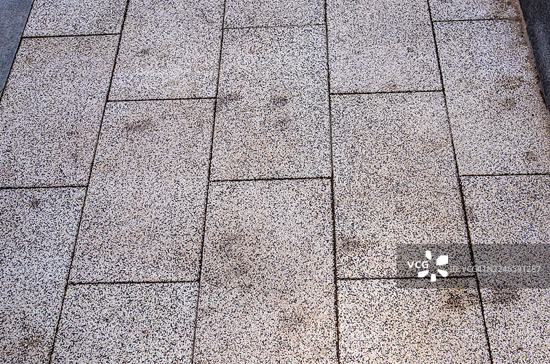 浅灰色纹理铺路石板构成的步行道全景，形成抽象图案图片素材