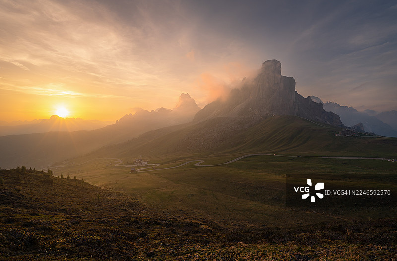 意大利圣维托迪卡多雷的贾乌山口，云彩和蜿蜒的道路映衬下的壮丽山景日落图片素材