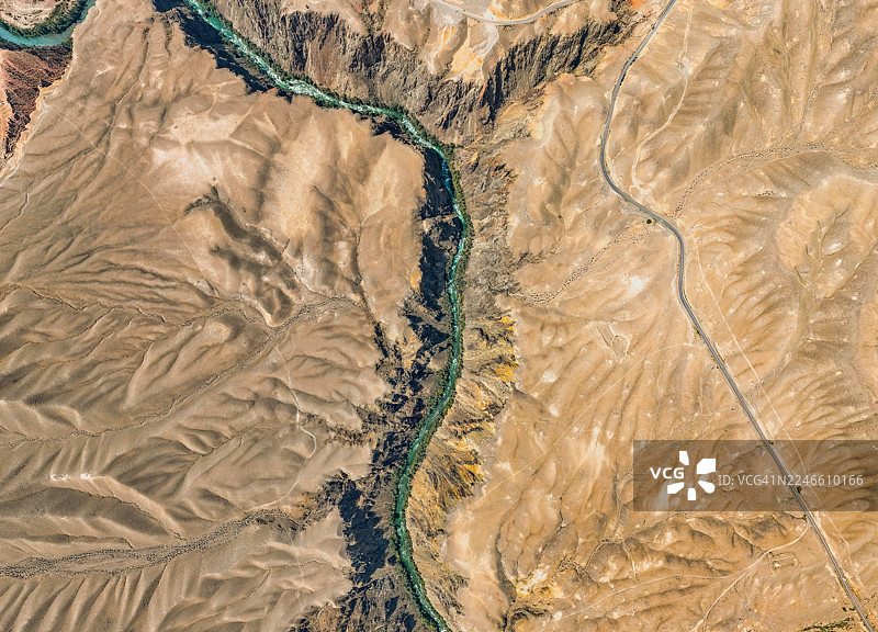 空中俯瞰中亚壮丽的查林峡谷，深邃的裂谷穿过干旱的平原，下方是碧绿的河流。图片素材