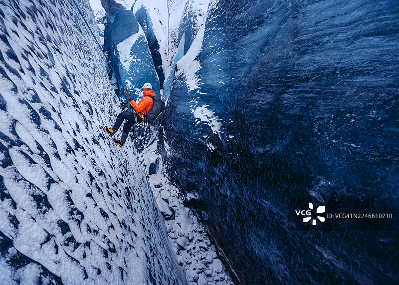 攀岩者下降到冰川裂缝中图片素材
