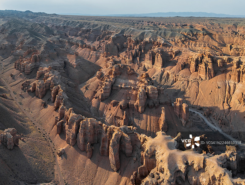 空中俯瞰中亚恰林峡谷的城堡谷，展示了高耸的岩石构造以及下午晚些时候穿过干旱峡谷的蜿蜒道路。图片素材