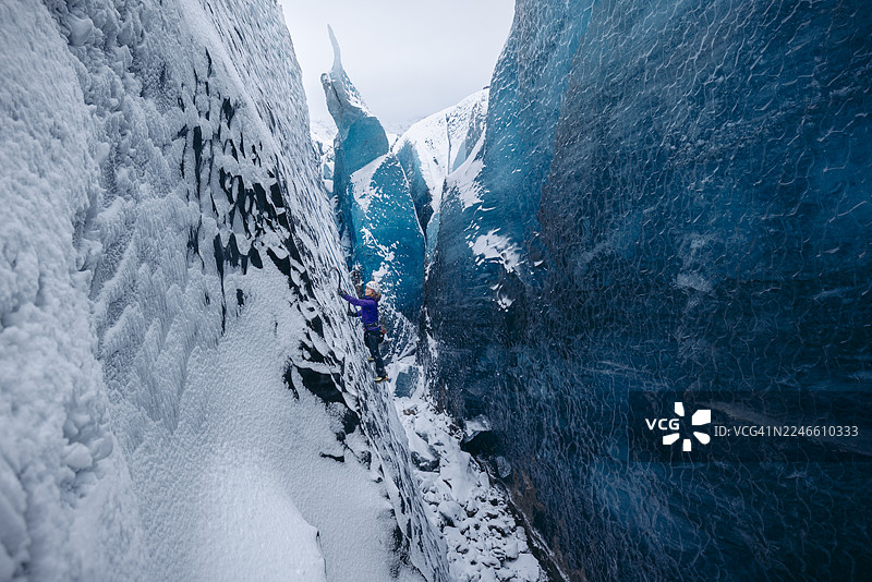 攀冰者攀登深邃的冰隙图片素材