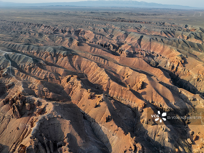 空中俯瞰中亚查林峡谷的城堡谷，展示了高耸的岩石构造以及傍晚时分穿过干旱峡谷的蜿蜒道路。图片素材