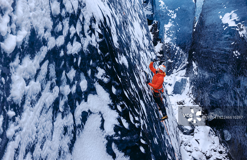 登山者在风暴中攀登蓝色冰川图片素材
