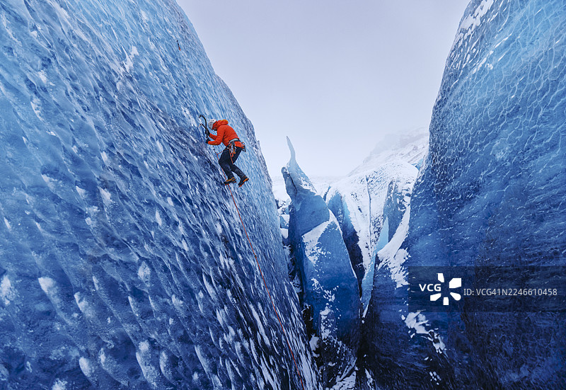 攀登者在风暴中攀登蓝色冰川图片素材