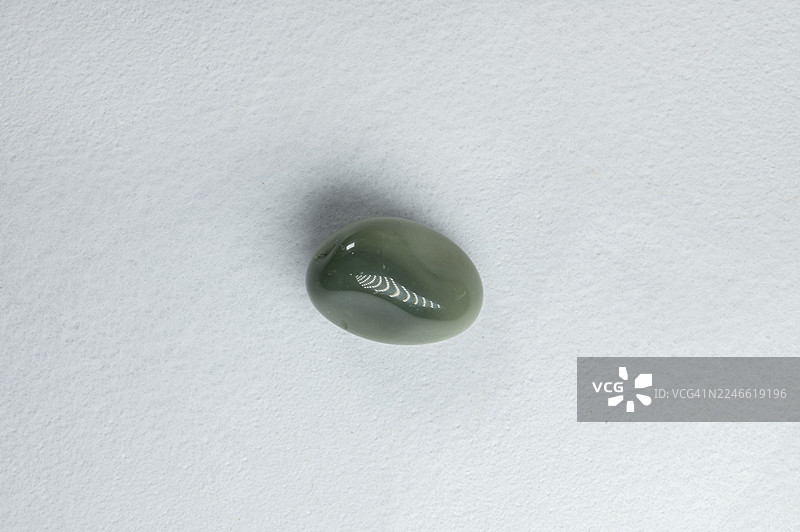 白色背景上孤立的小绿石头。图片素材