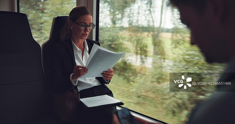 一位职业女性在上班途中，处理与项目更新、报告和日程相关的公务，进行财务研究、管理和公共交通通勤。图片素材