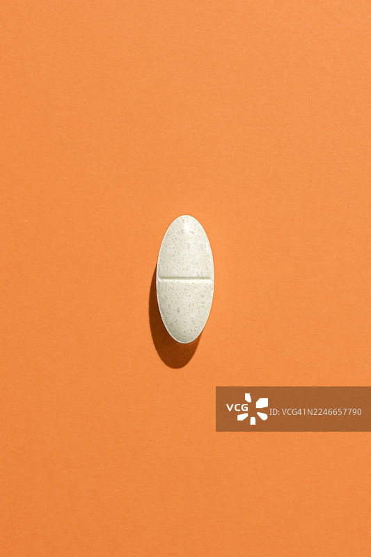 橙色背景上的椭圆形药丸图片素材