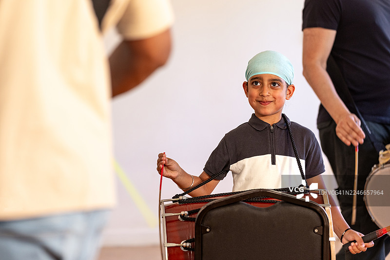 快乐的男孩在学习打鼓图片素材