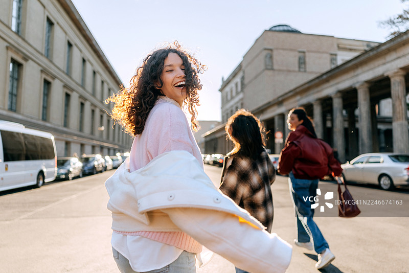 三位女性朋友在柏林廊柱旁散步图片素材