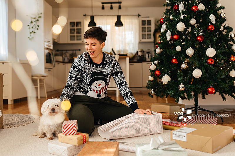 喜庆的女人在狗狗旁边包装礼物图片素材