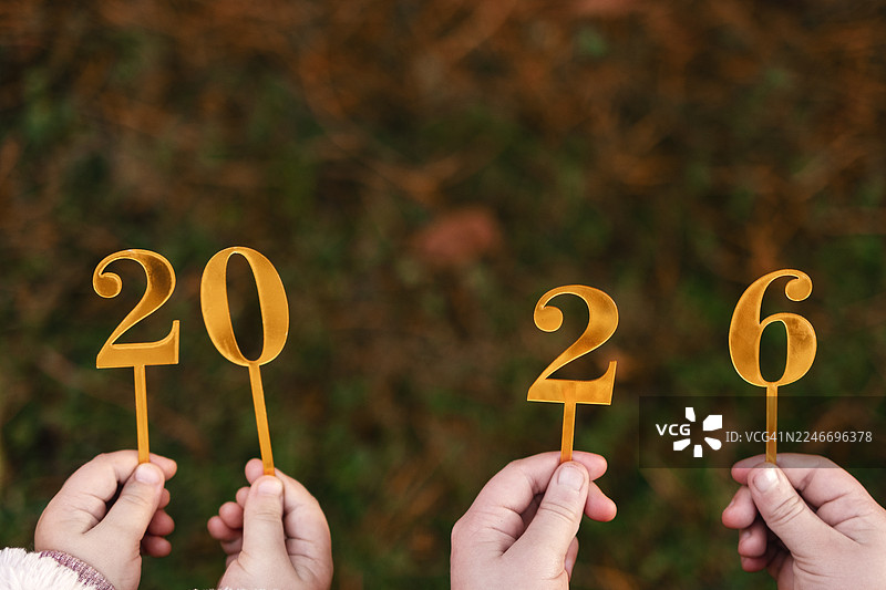 孩子们在户外手持金色“2026”数字道具庆祝新年图片素材