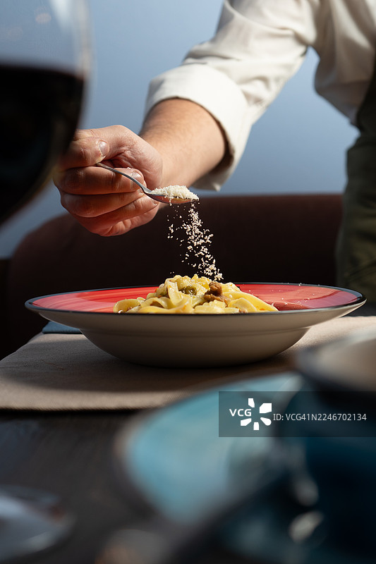餐馆里盘子里的意面配豌豆、肉和奶酪图片素材