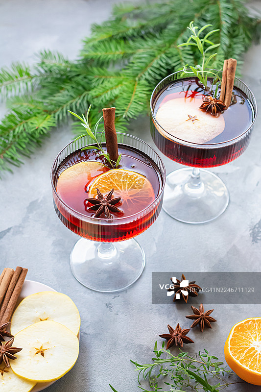 杯中的热红酒、水果和香料潘趣酒。一种传统的冬季饮品。圣诞和新年的氛围。图片素材