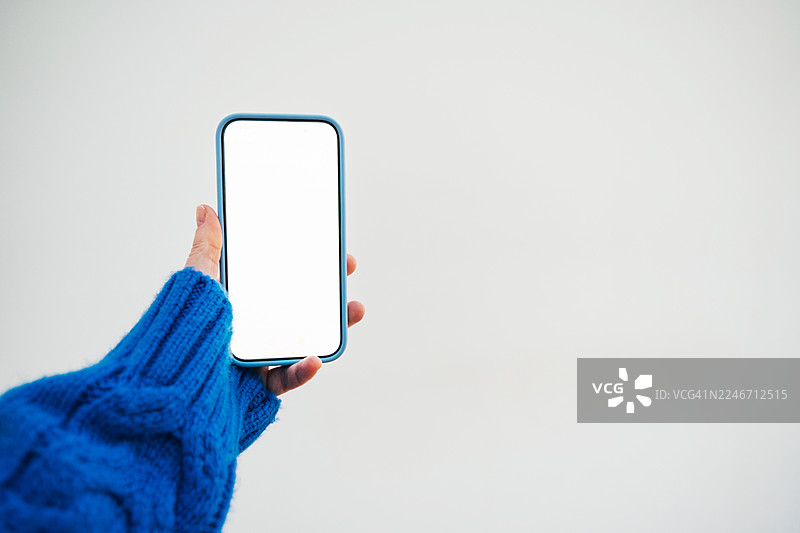 一只手拿着带有Bbank界面的智能手机，背景为浅色图片素材