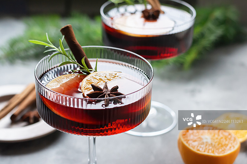 玻璃杯中的热红酒、水果和香料潘趣酒。一种传统的冬季饮品。圣诞和新年的氛围。图片素材