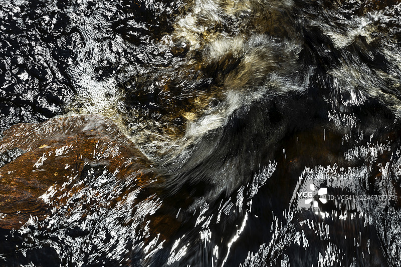 斯堪的纳维亚的溪流，水流湍急，水面有倒影和漩涡，长曝光拍摄，瑞典图片素材