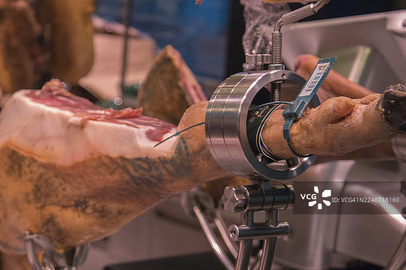 金属雕刻架上放着伊比利亚火腿准备切片图片素材