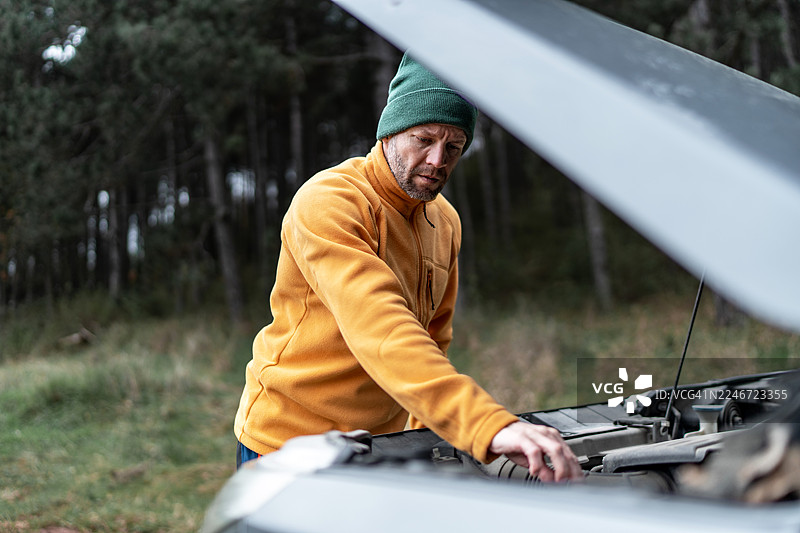 男人在森林里因汽车故障检查引擎图片素材