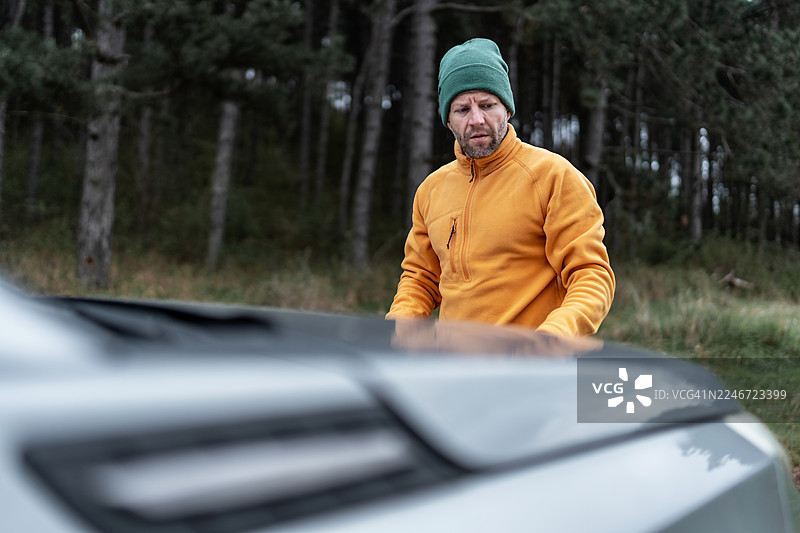 一名男子在乡村森林公路上面临汽车故障图片素材