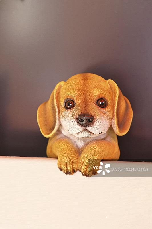 德国北莱茵-威斯特法伦州维尔恩斯多夫，一只陶瓷狗在花园里专注地凝视图片素材