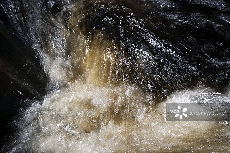 瑞典，长曝光拍摄的溪流，水色深沉，带有水流反射和湍流图片素材