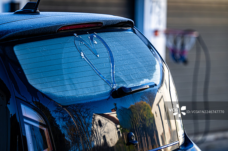 寒冷的夜晚来临，车窗上的霜花被画上了一个爱心图片素材