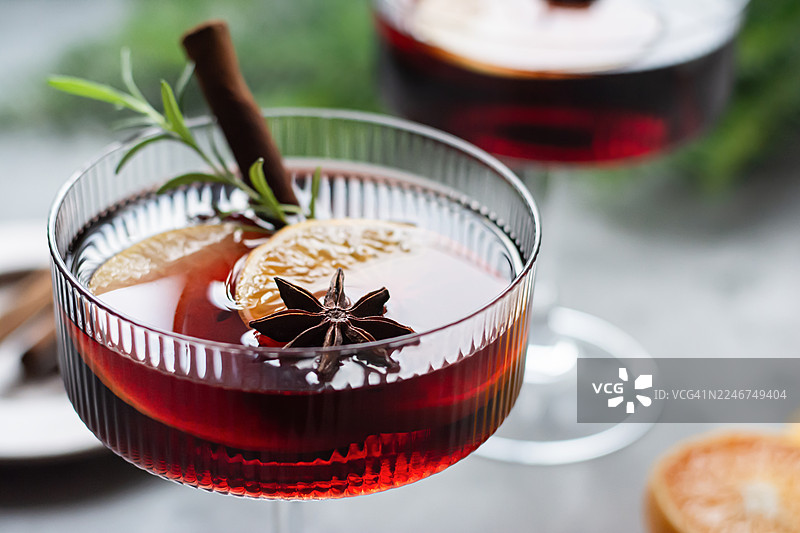 玻璃杯中的热红酒、水果和香料潘趣酒。一种传统的冬季饮品。圣诞和新年的氛围。图片素材