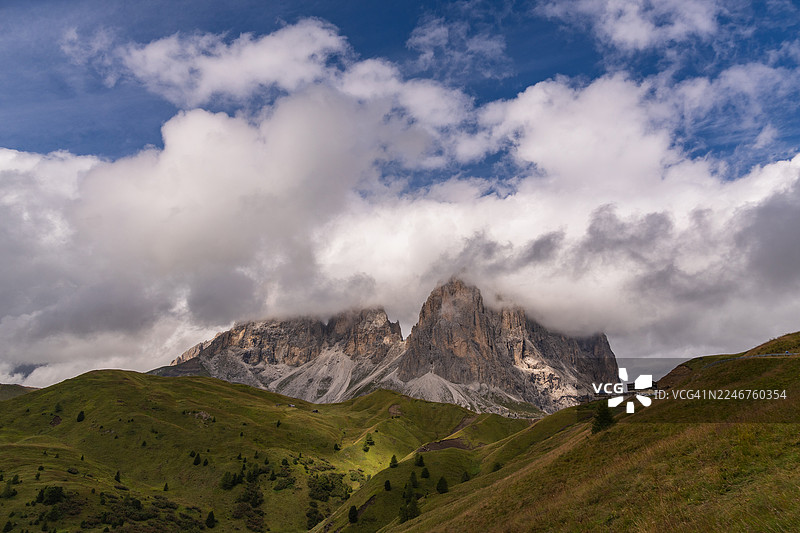 戏剧性的云彩笼罩着风景如画的山谷中雄伟的山峰，意大利格尔达纳山谷图片素材