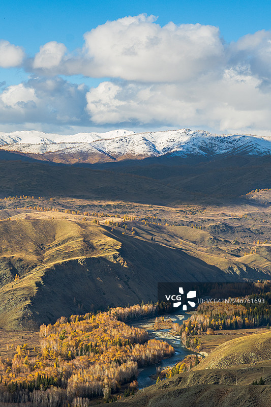 中国秋季山谷中蜿蜒的河流的壮丽鸟瞰图，背景是蓝天下白雪皑皑的山峰图片素材